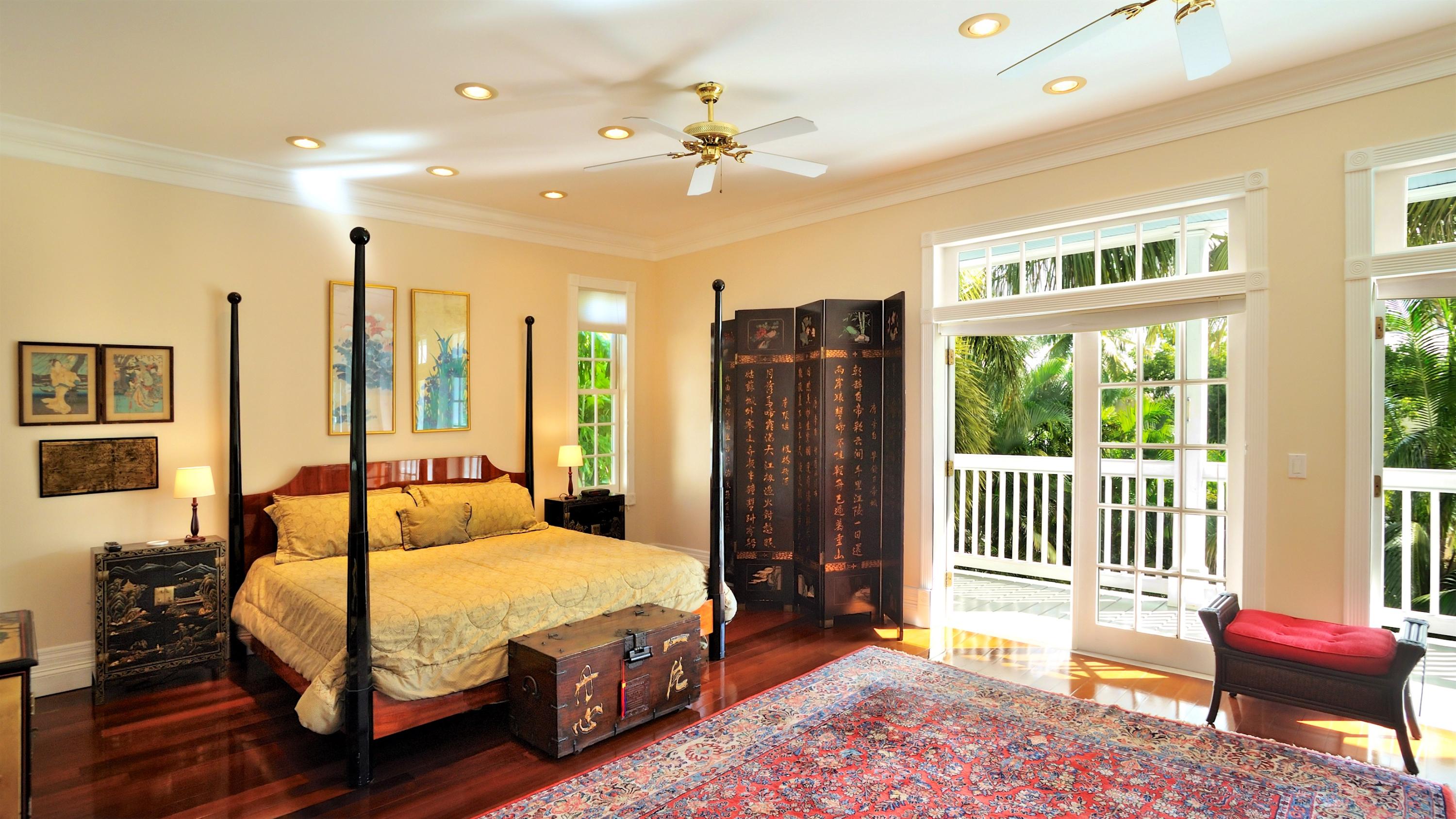 58 Front Street Key West, FL 33040 - Photo 15 of 28 a spacious bedroom with a bed and a chandelier