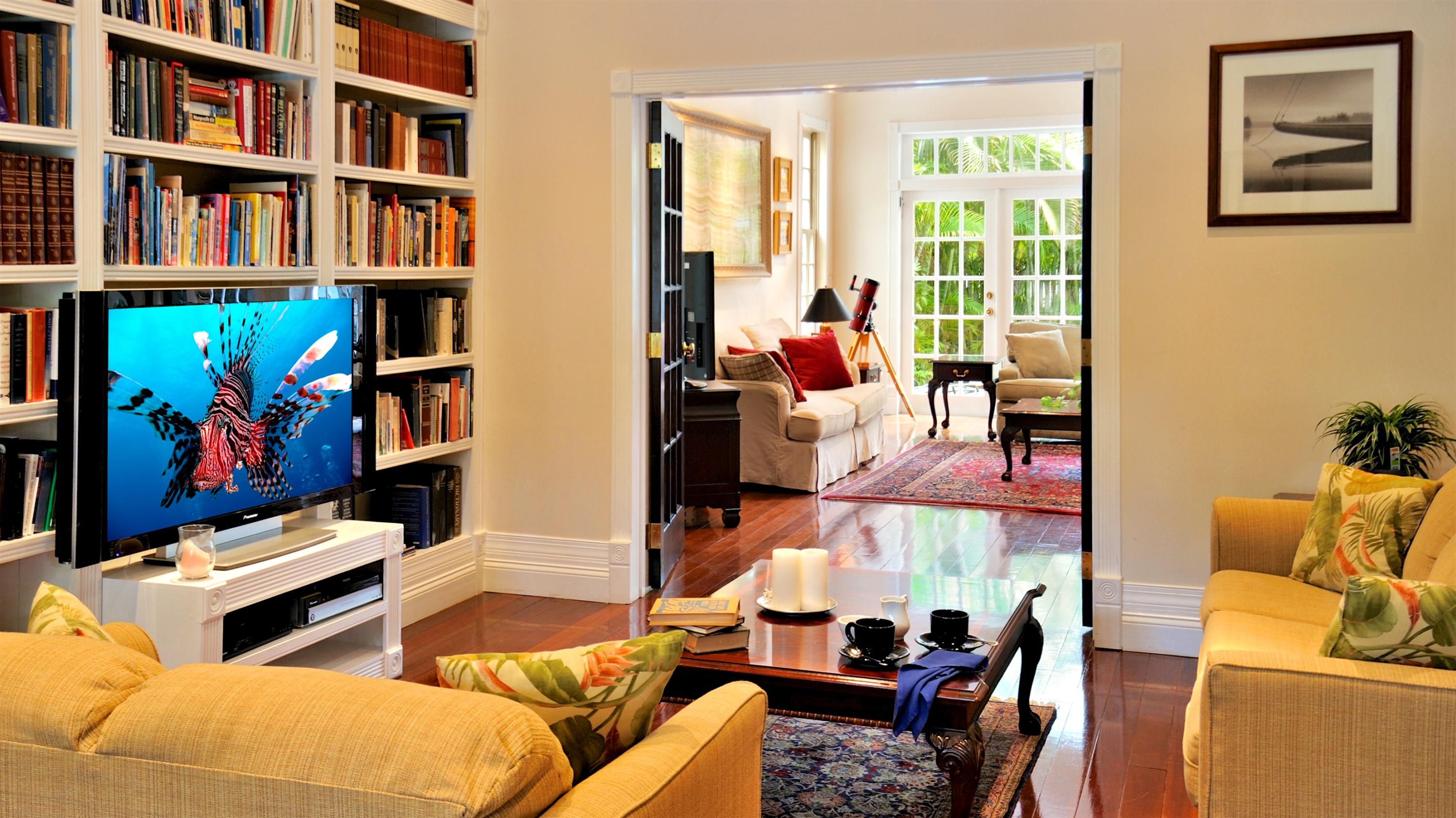 58 Front Street Key West, FL 33040 - Photo 6 of 28 a living room with furniture a bookshelf and a window