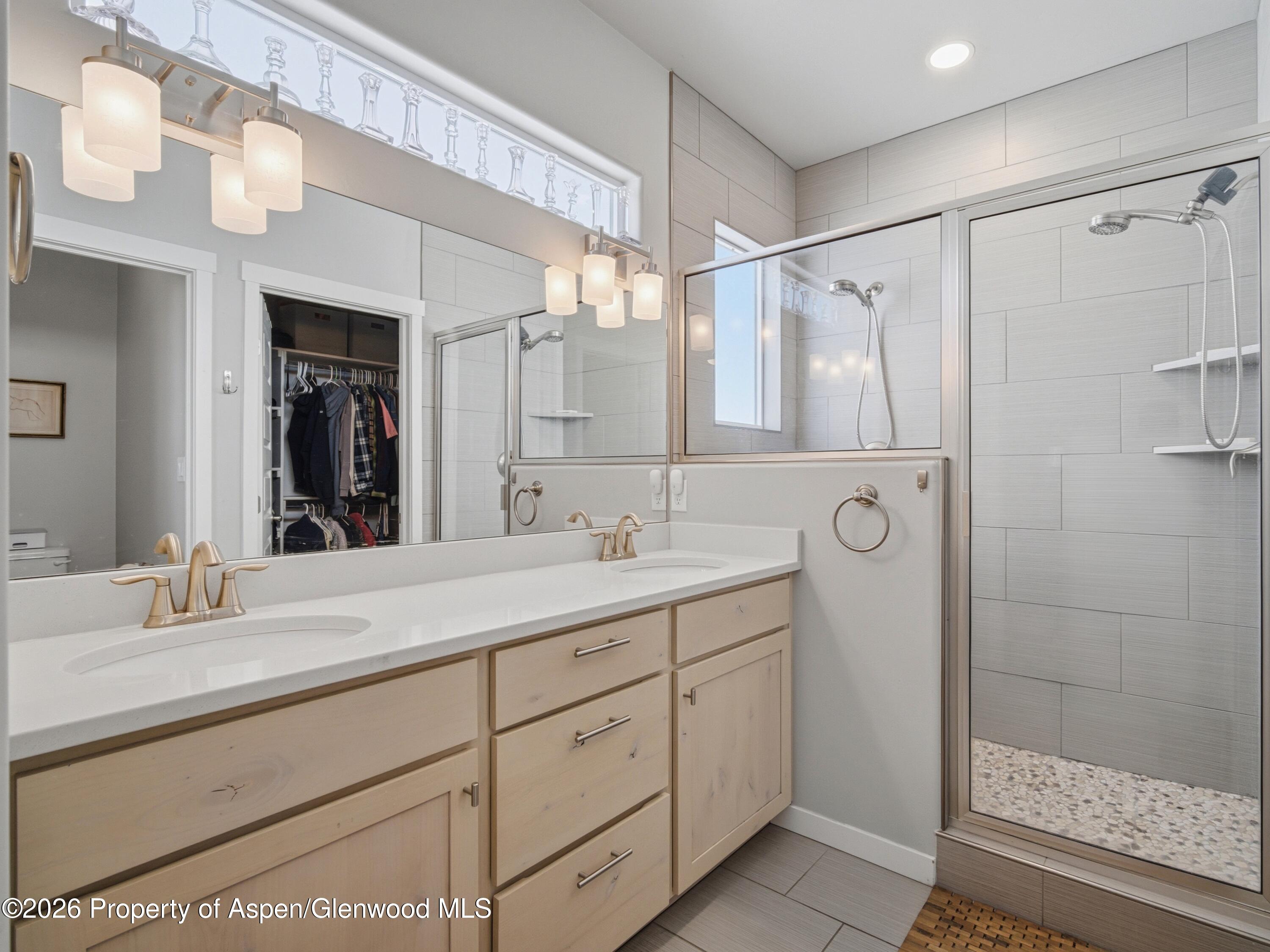 563 Red Cedar Way Grand Junction, CO 81504 - Photo 17 of 30 a bathroom with a double vanity sink mirror double and shower