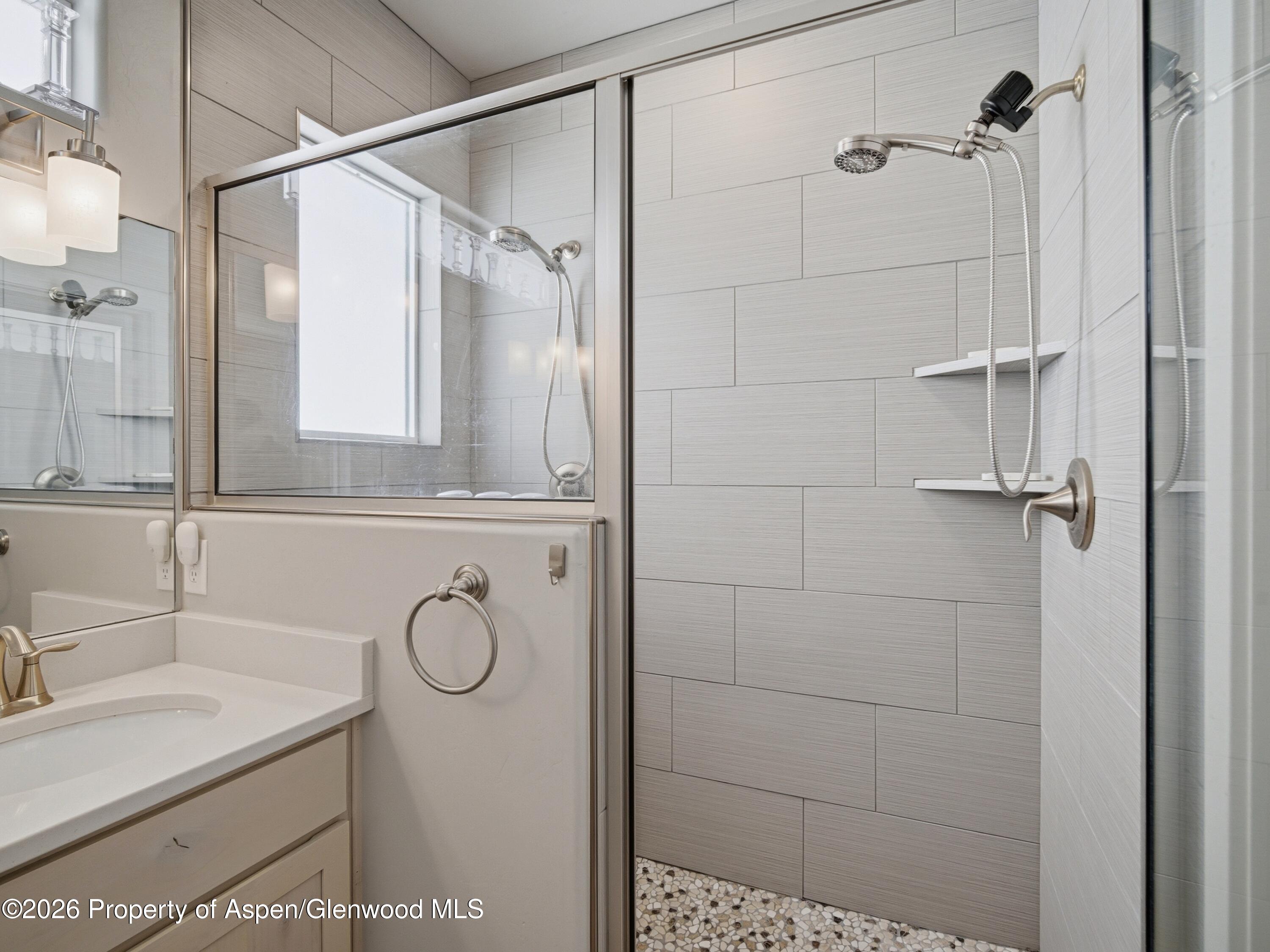 563 Red Cedar Way Grand Junction, CO 81504 - Photo 18 of 30 a bathroom with a granite countertop shower sink and mirror