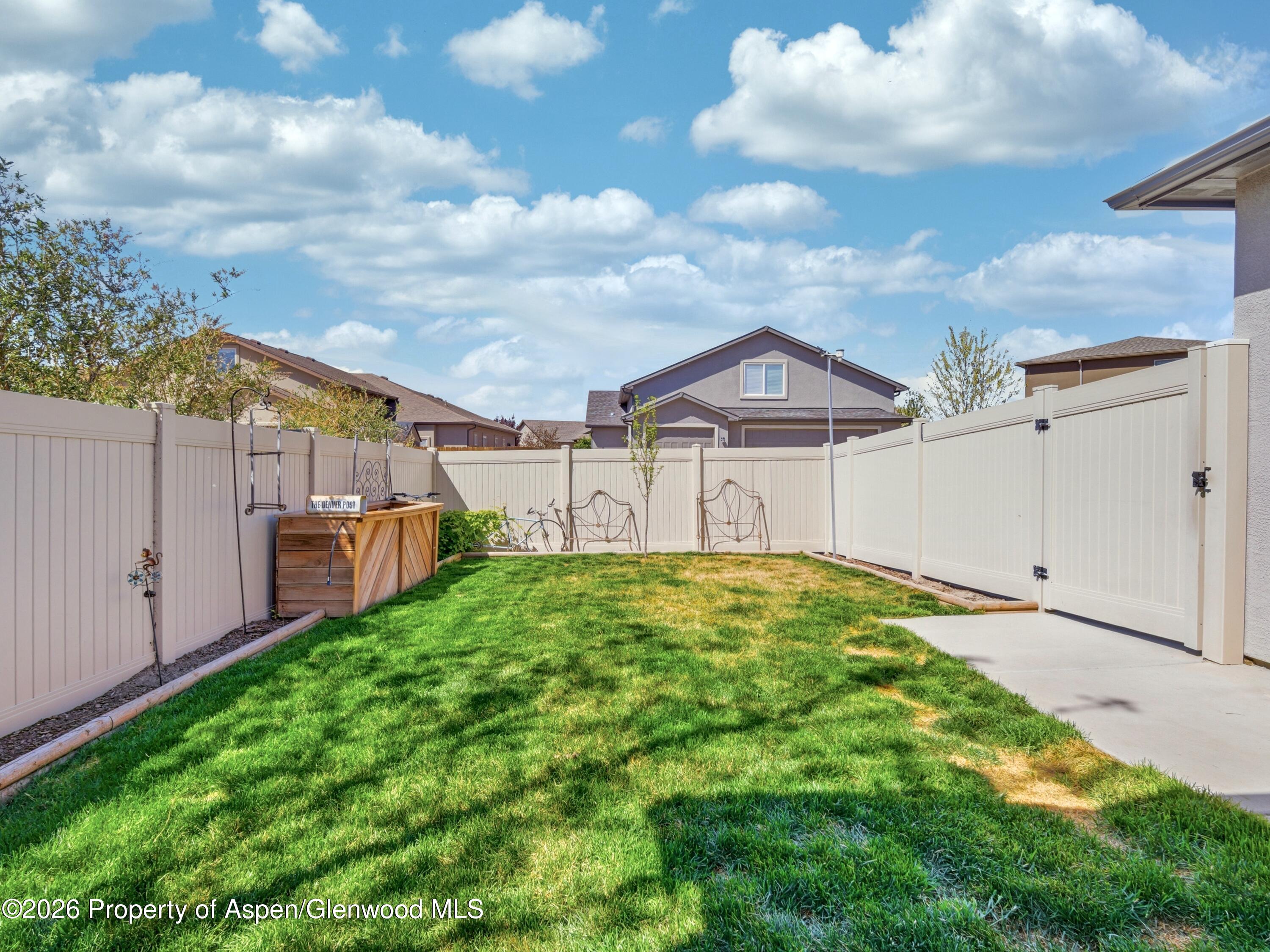 563 Red Cedar Way Grand Junction, CO 81504 - Photo 28 of 30 a view of a yard in front of a house with plants and wooden fence