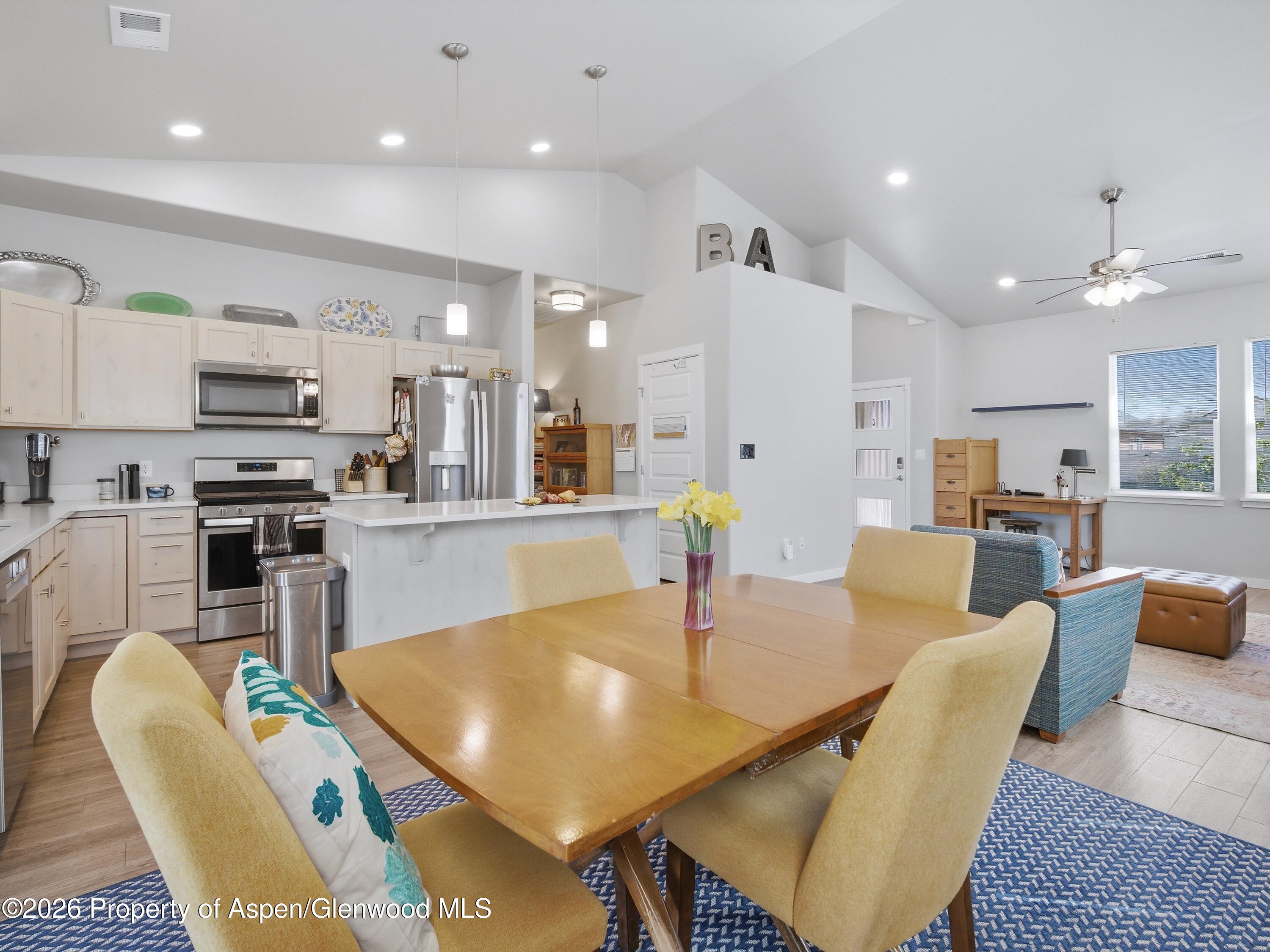 563 Red Cedar Way Grand Junction, CO 81504 - Photo 8 of 30 a dining room with kitchen island furniture a chandelier and kitchen view