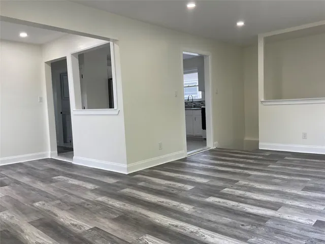 a view of an empty room with wooden floor and closet