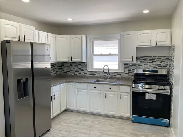 a kitchen with stainless steel appliances granite countertop a stove a refrigerator and a granite counter tops