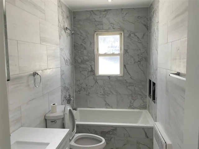 a bath room with a toilet and a bath tub