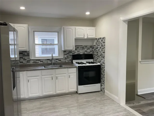 a kitchen with granite countertop white cabinets and appliances