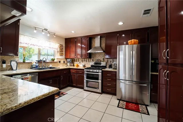 a kitchen with stainless steel appliances granite countertop a refrigerator a sink a stove a microwave and island