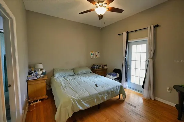 a bedroom with a bed and wooden floor