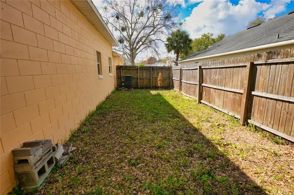 a view of backyard with wooden fence