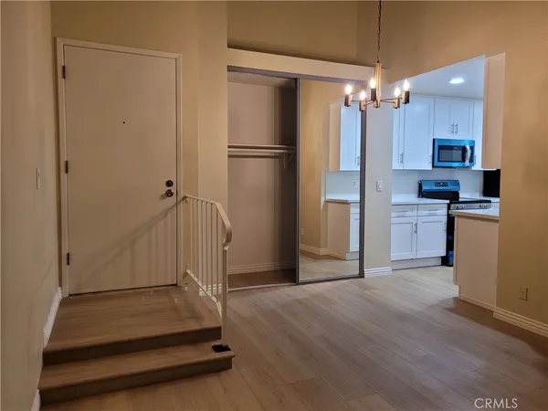 an empty room with chandelier fan and windows