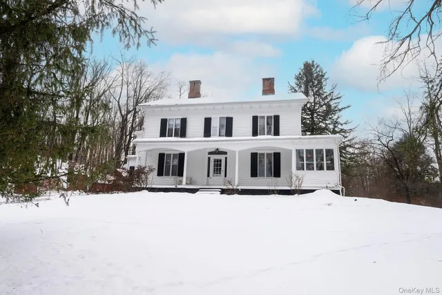 a front view of a house with a yard covered in snow