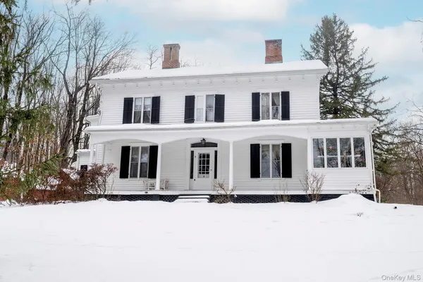 a front view of a house with yard covered in snow