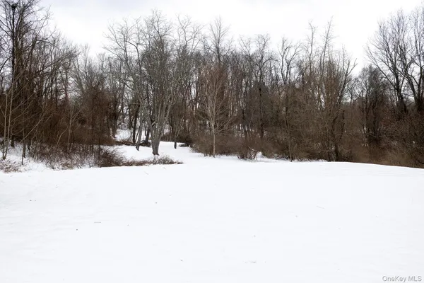 a view of wooden fence and trees in the background