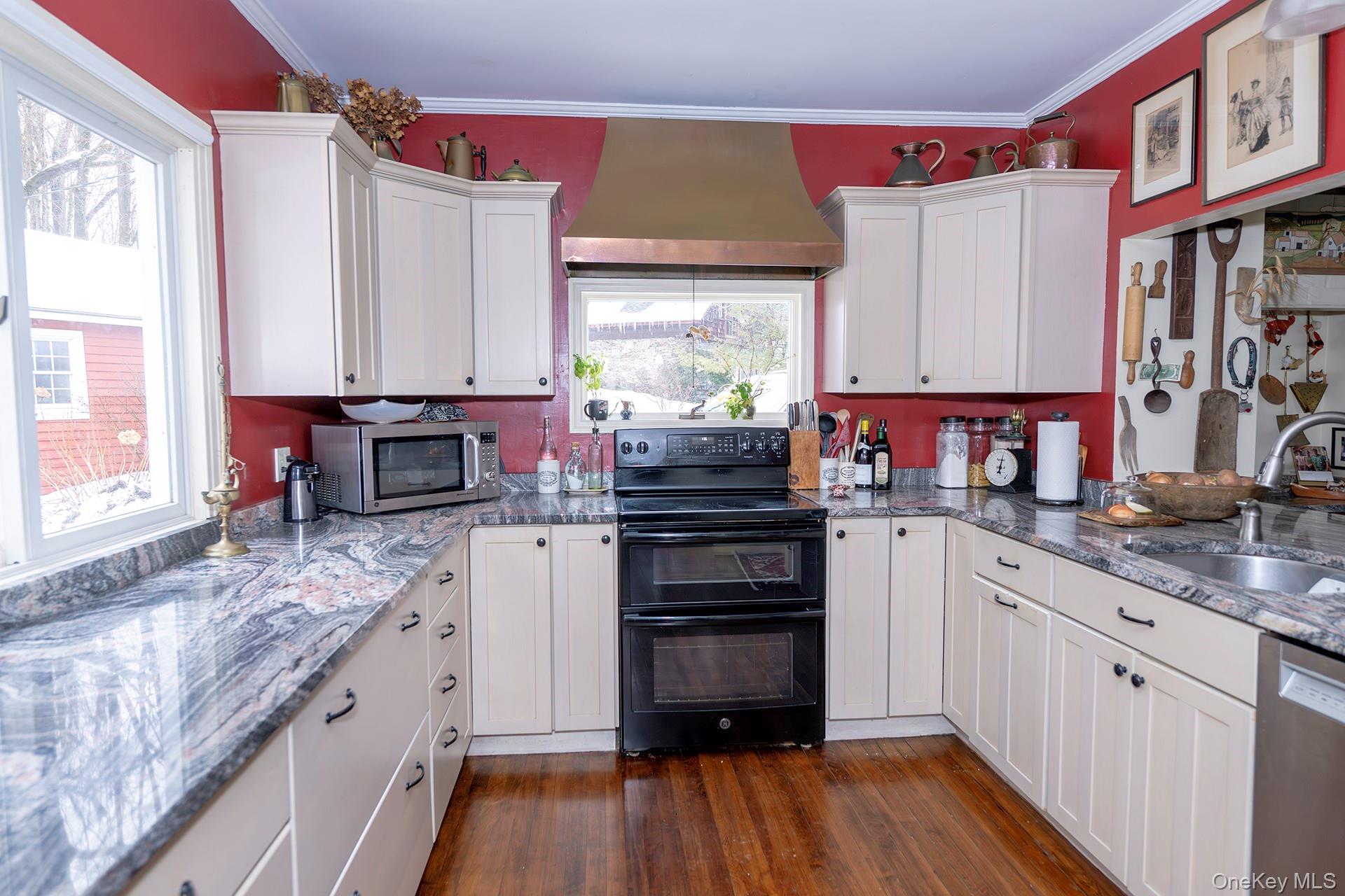 819 Van Wagner Road Poughkeepsie, NY 12601 - Photo 6 of 43 Kitchen featuring stainless steel appliances, custom range hood, white cabinetry, dark stone countertops, and ornamental molding