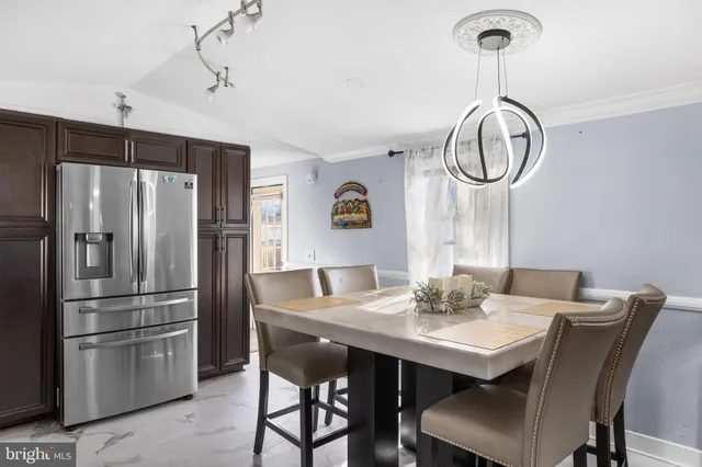 a kitchen with stainless steel appliances a table chairs and refrigerator