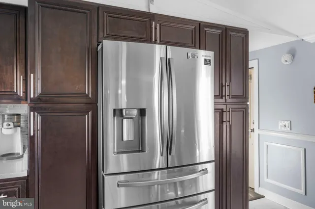 a metallic refrigerator freezer sitting in a kitchen