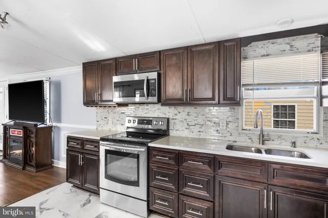 a kitchen with stainless steel appliances a stove sink microwave and cabinets