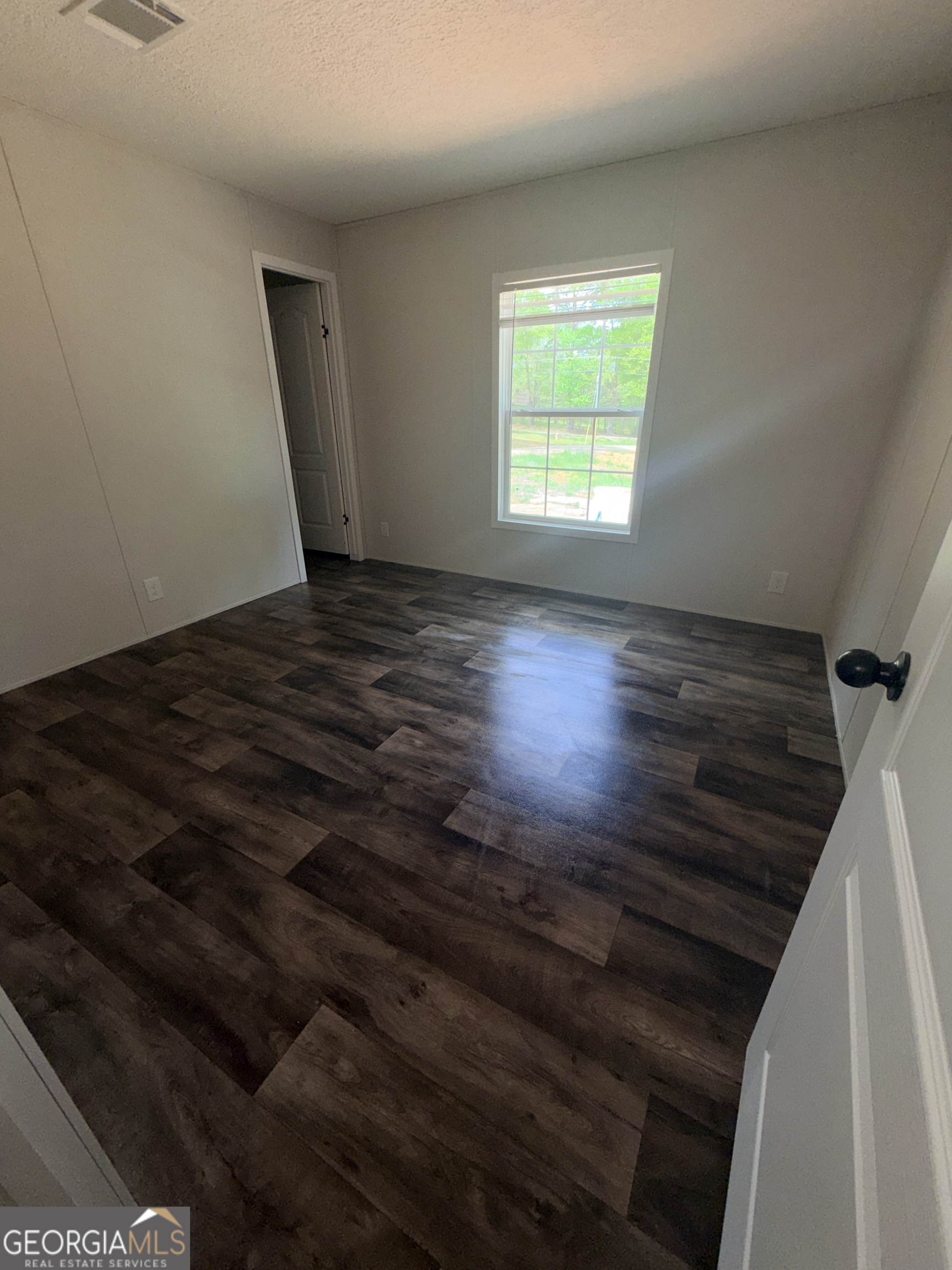 225 Rehoboth Road Bowman, GA 30624 - Photo 8 of 18 a view of an empty room with wooden floor and a window