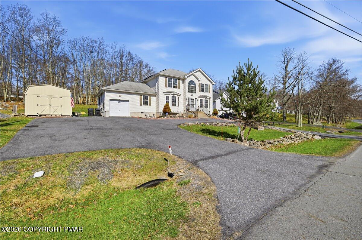 4373 Pine Ridge Drive East Bushkill, PA 18324 - Photo 2 of 33 a front view of a house with a yard and garage