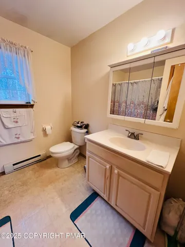 a spacious bathroom with a toilet a sink and a mirror