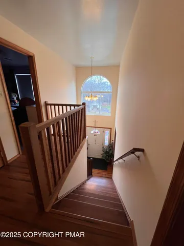 a view of hallway with wooden floor and stairs