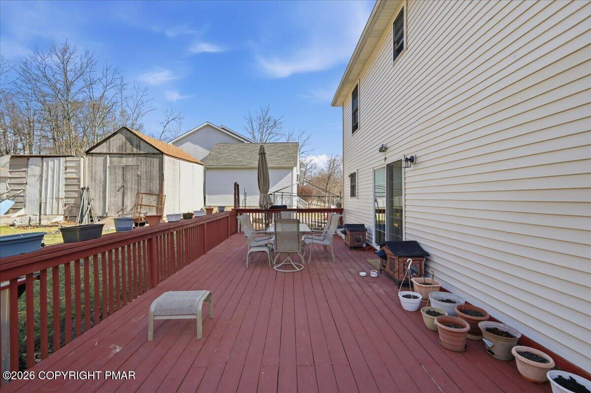 4373 Pine Ridge Drive East Bushkill, PA 18324 - Photo 4 of 33 a view of a roof deck with table and chairs a barbeque with wooden floor and fence