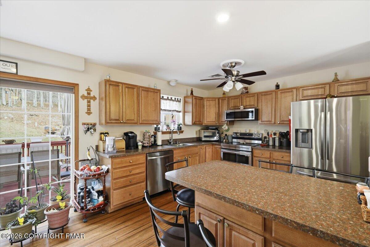 4373 Pine Ridge Drive East Bushkill, PA 18324 - Photo 8 of 33 a kitchen with granite countertop a table chairs stove and refrigerator