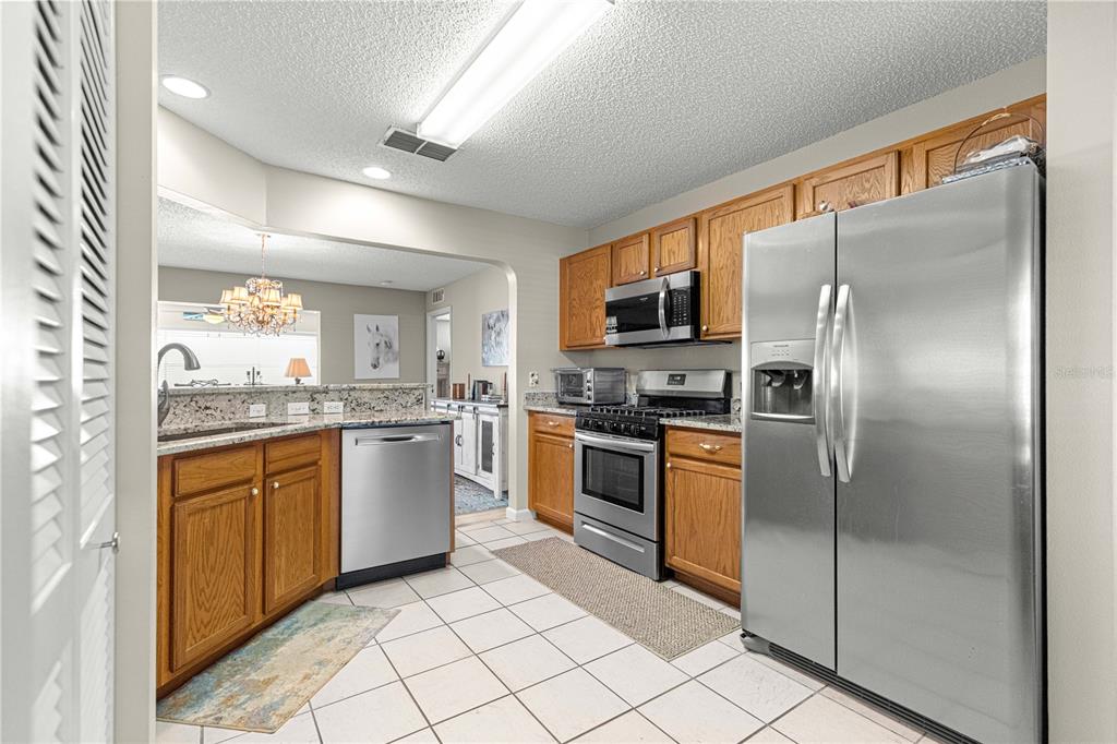 9746 Southwest 96th Street Ocala, FL 34481 - Photo 13 of 57 a kitchen with stainless steel appliances granite countertop a refrigerator and a stove top oven