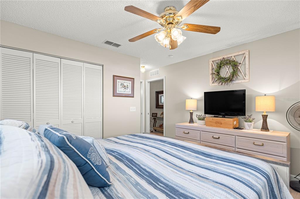 9746 Southwest 96th Street Ocala, FL 34481 - Photo 34 of 57 a bedroom with a bed and a flat screen tv