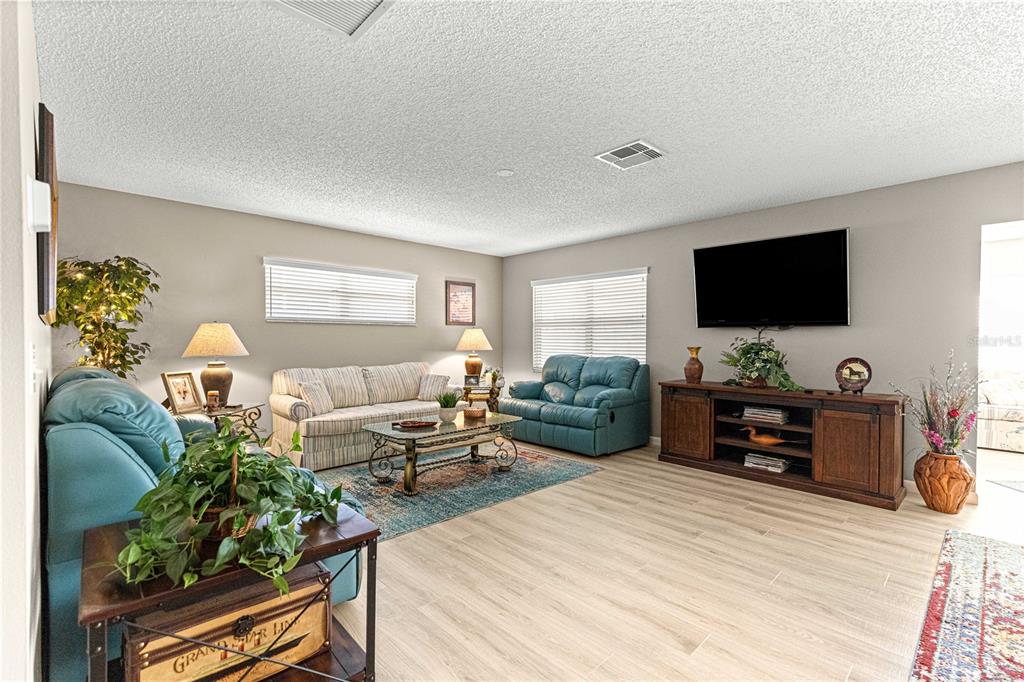 9746 Southwest 96th Street Ocala, FL 34481 - Photo 7 of 57 a bedroom with furniture potted plant and a flat screen tv