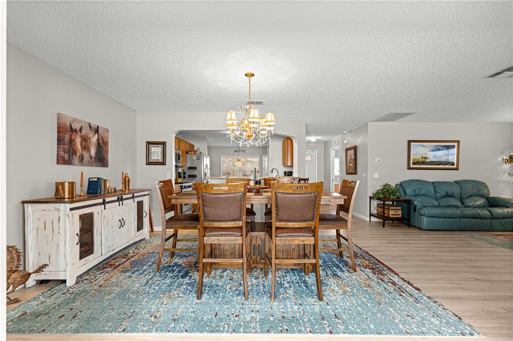9746 Southwest 96th Street Ocala, FL 34481 - Photo 9 of 57 a living room with furniture a chandelier and a dining table