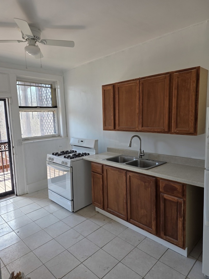 1853 East 79th Street, Unit 2 Chicago, IL 60649 - Photo 10 of 14 a kitchen with granite countertop a sink stove and cabinets