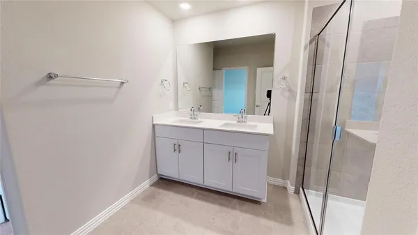 a spacious bathroom with a double vanity sink and a mirror