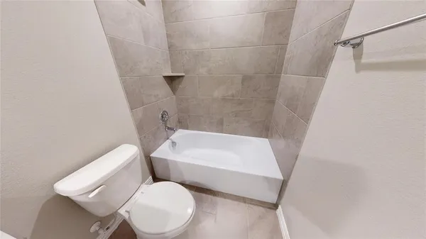 a white toilet sitting next to a white tub