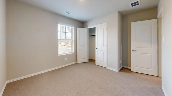 an empty room with windows and closet