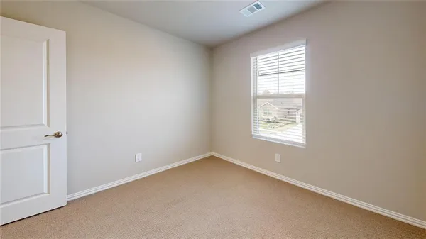 an empty room with a window and a ceiling fan