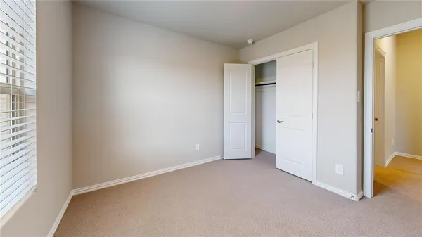 an empty room with a bathroom and mirror