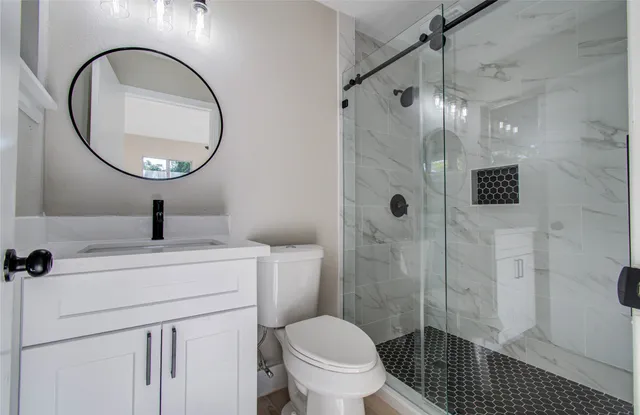 a bathroom with a toilet a sink and a mirror