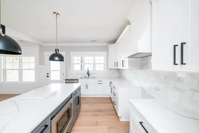 a kitchen with stainless steel appliances a sink a stove and a wooden floors