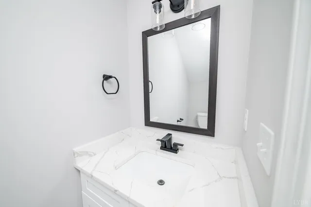 a view of an empty room with a window and kitchen view