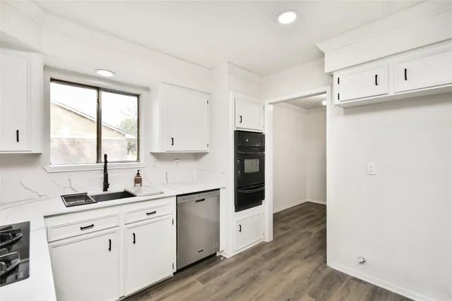 a kitchen with white cabinets and white appliances
