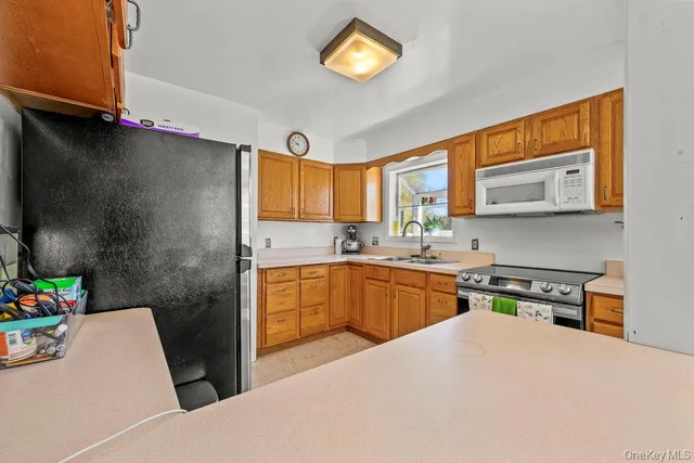 a kitchen with stainless steel appliances a microwave a sink and cabinets