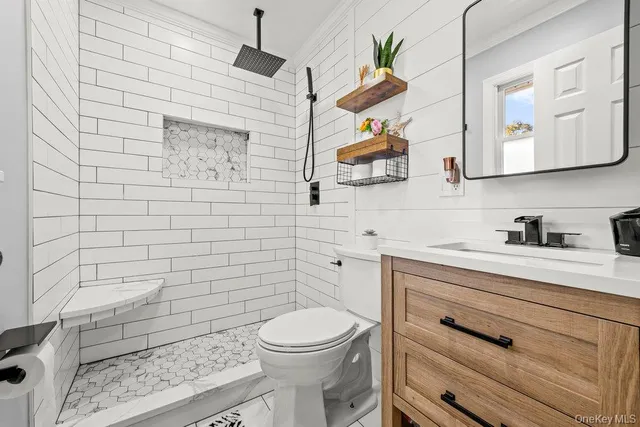 a bathroom with a toilet a sink a mirror and vanity