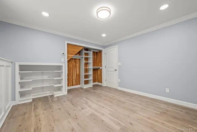 a view of an empty room with wooden floor and closet