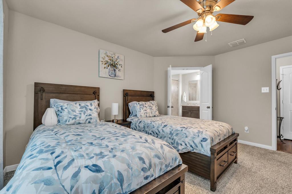 917 North Fork Ranch Road Waco, TX 76705 - Photo 11 of 23 a bedroom with two beds and a chandelier