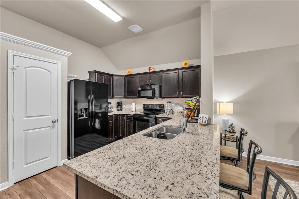 917 North Fork Ranch Road Waco, TX 76705 - Photo 8 of 23 a kitchen with stainless steel appliances wooden floor dining table and chairs