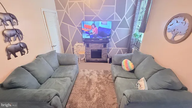 a living room with furniture and a white wall