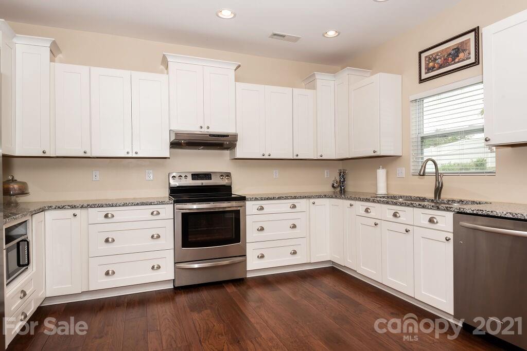 305 Allspice Road Fort Mill, SC 29708 - Photo 16 of 31 a kitchen with granite countertop white cabinets white stainless steel appliances and sink