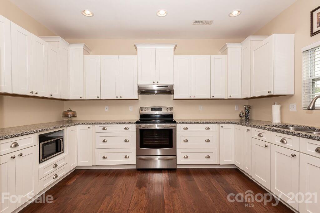 305 Allspice Road Fort Mill, SC 29708 - Photo 17 of 31 a kitchen with stainless steel appliances granite countertop a stove and white cabinets