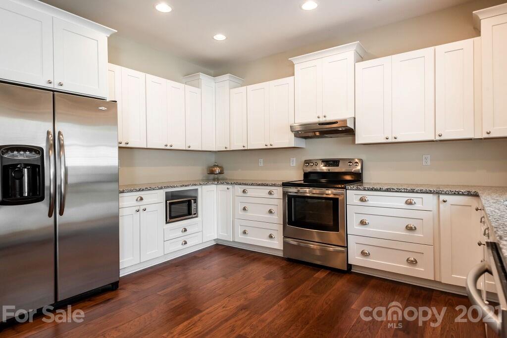 305 Allspice Road Fort Mill, SC 29708 - Photo 18 of 31 a kitchen with cabinets stainless steel appliances and wooden floor